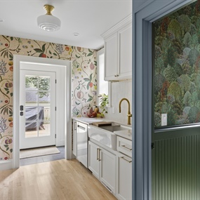 Updated kitchen with white cabinets and floral wallpaper next to a dark green powder room in King Field.
