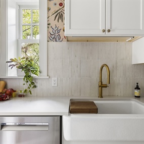 Kitchen sink area featuring white cabinetry, brass faucet, and colorful floral wallpaper in a King Field home.