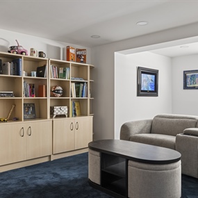 Custom built-in bookshelves and spacious sectional seating in a remodeled Lynnhurst basement.